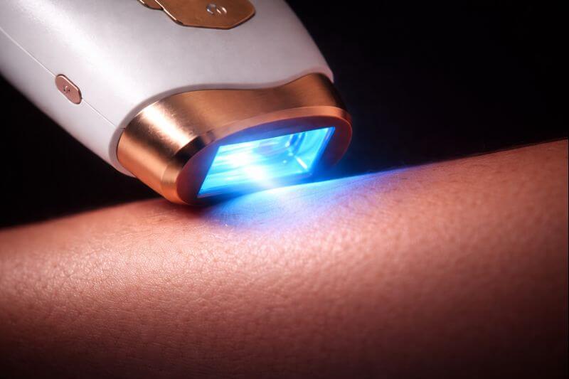 Primer plano de la depiladora IPL Lumira Silq activando su tecnología Ice-Shield de luz pulsada sobre la piel para eliminar el vello de raíz sin dolor.